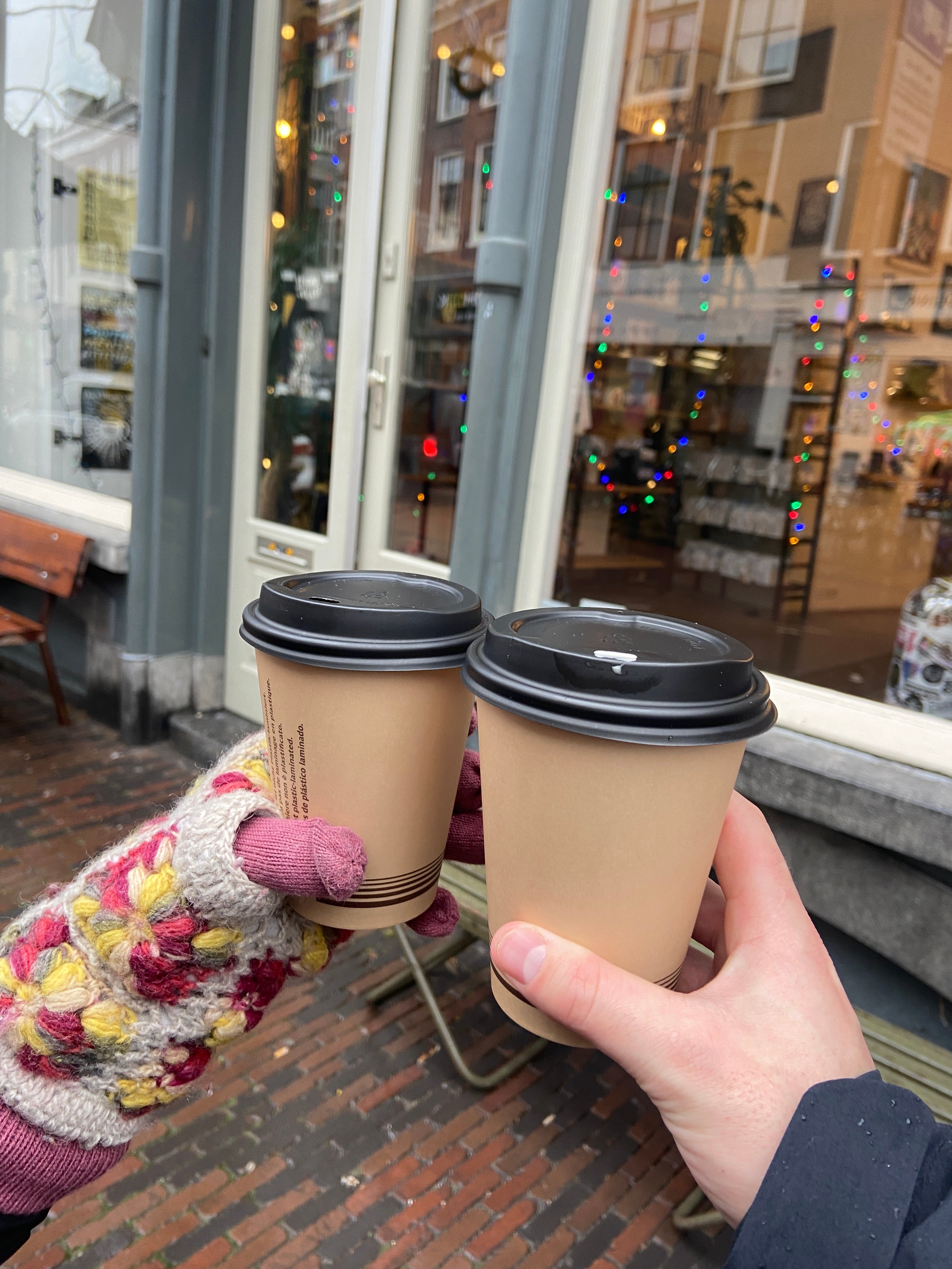 Coffee cups doing a cheers outside during Christmas in Amsterdam